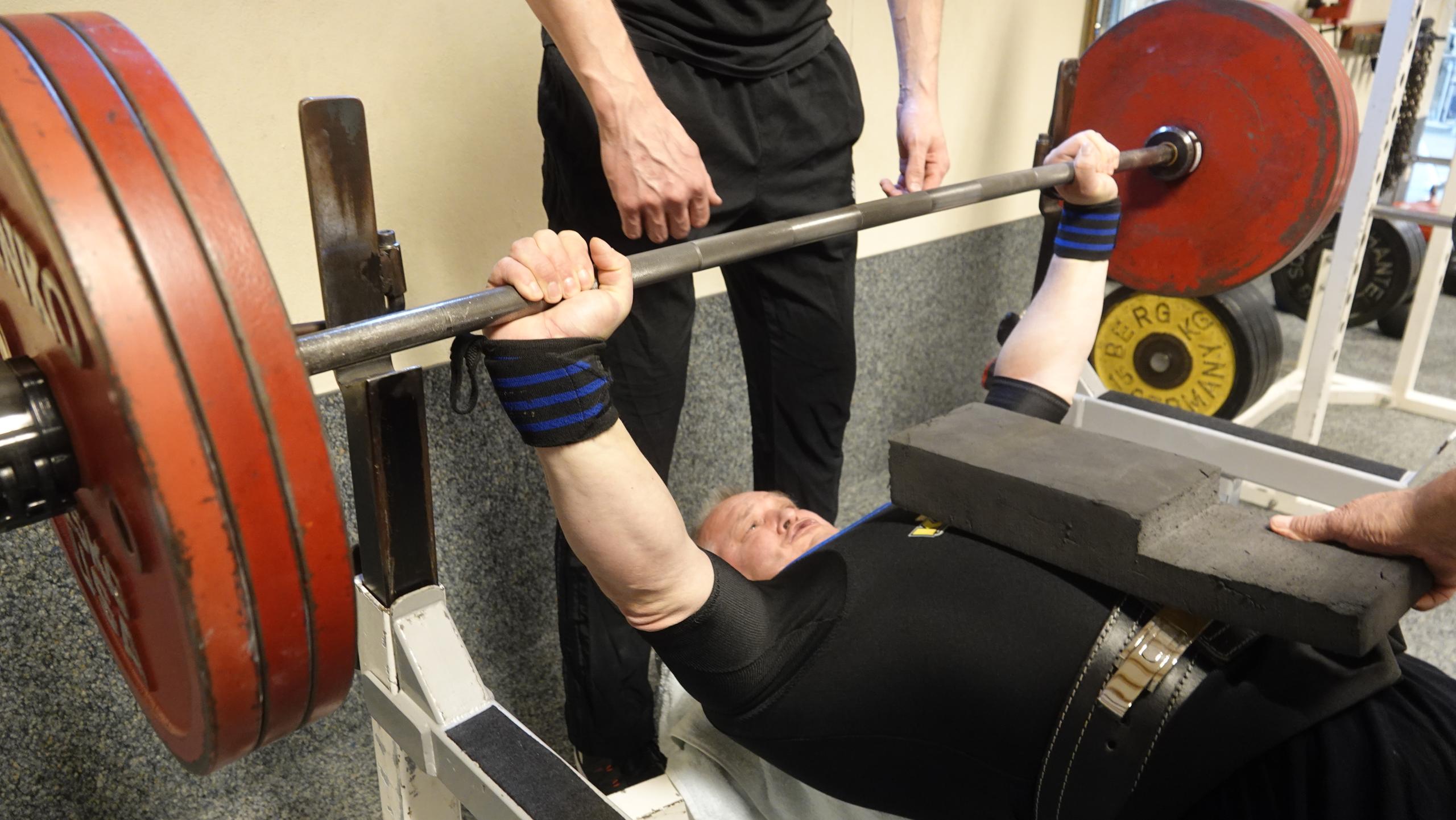 Trainer Kristian beim Bankdrücken in der Fitnesshalle