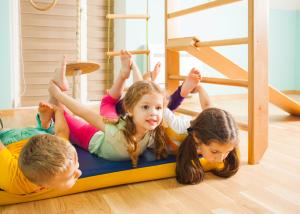Kinder spielen und turnen auf der Matte, an Geräte oder der gesamten Halle