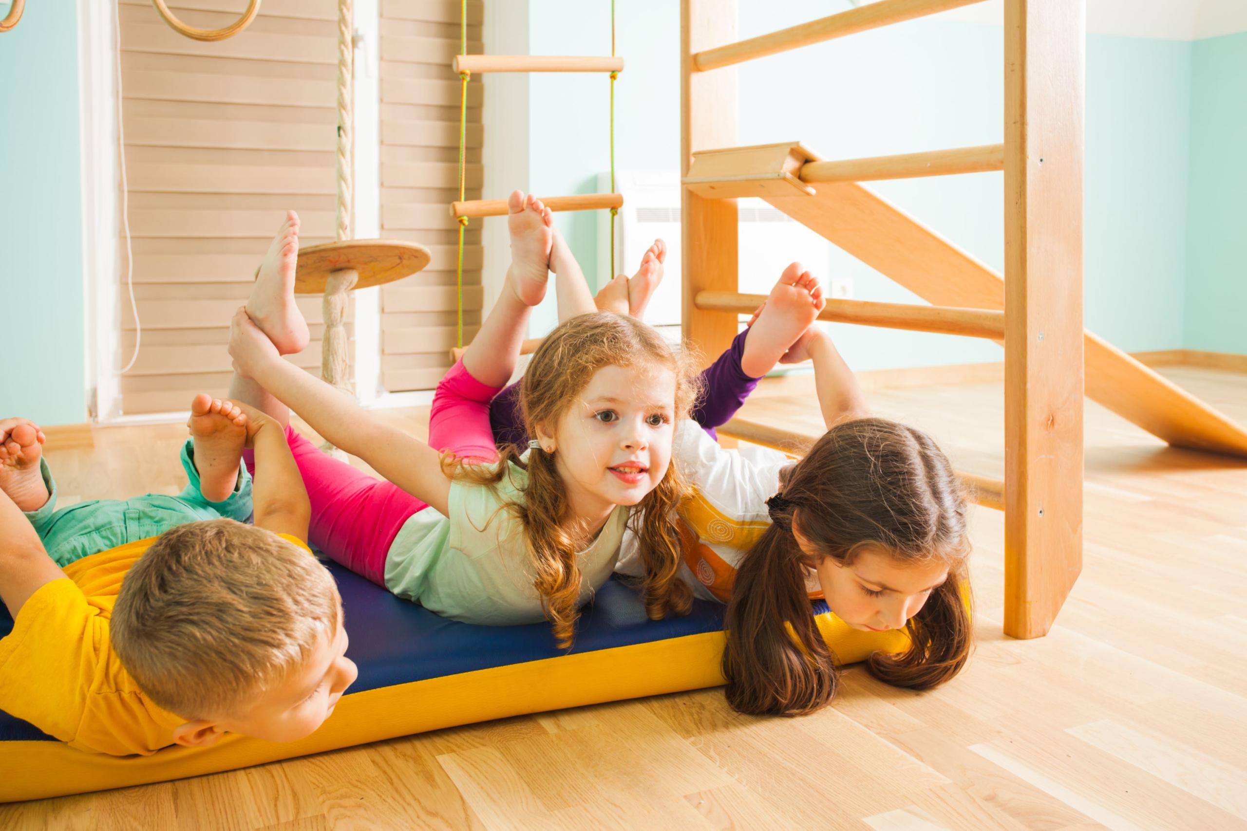 Kinder spielen und turnen auf der Matte, an Geräte oder der gesamten Halle